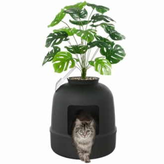Cat sitting in a planter-shaped litter box with a faux plant on top.