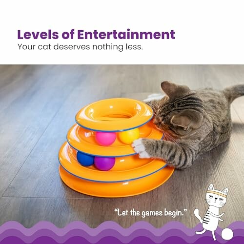 Cat playing with an orange multi-level toy with colorful balls.