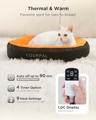 White cat lying on an orange and black heated cat bed with remote control features.